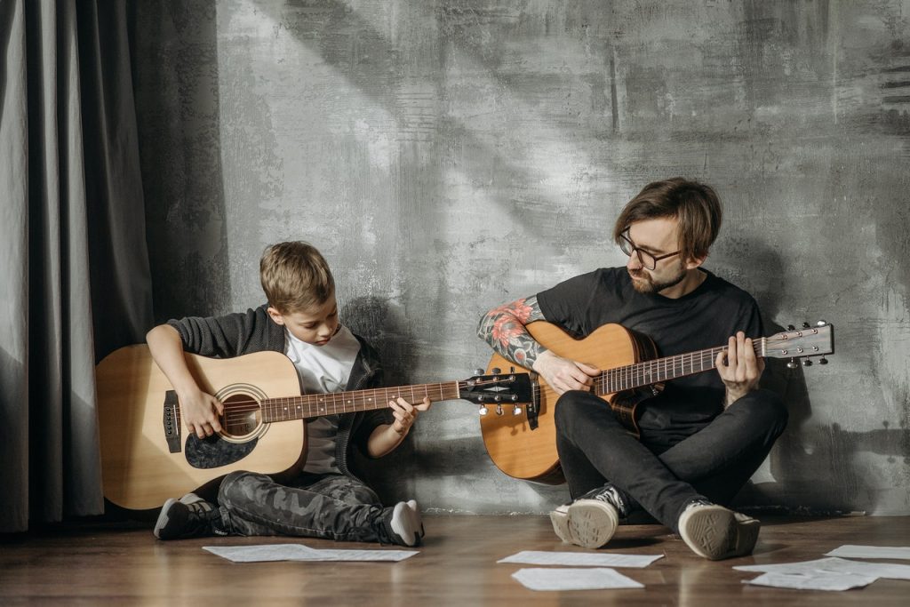 Kid learning how to play the guitar